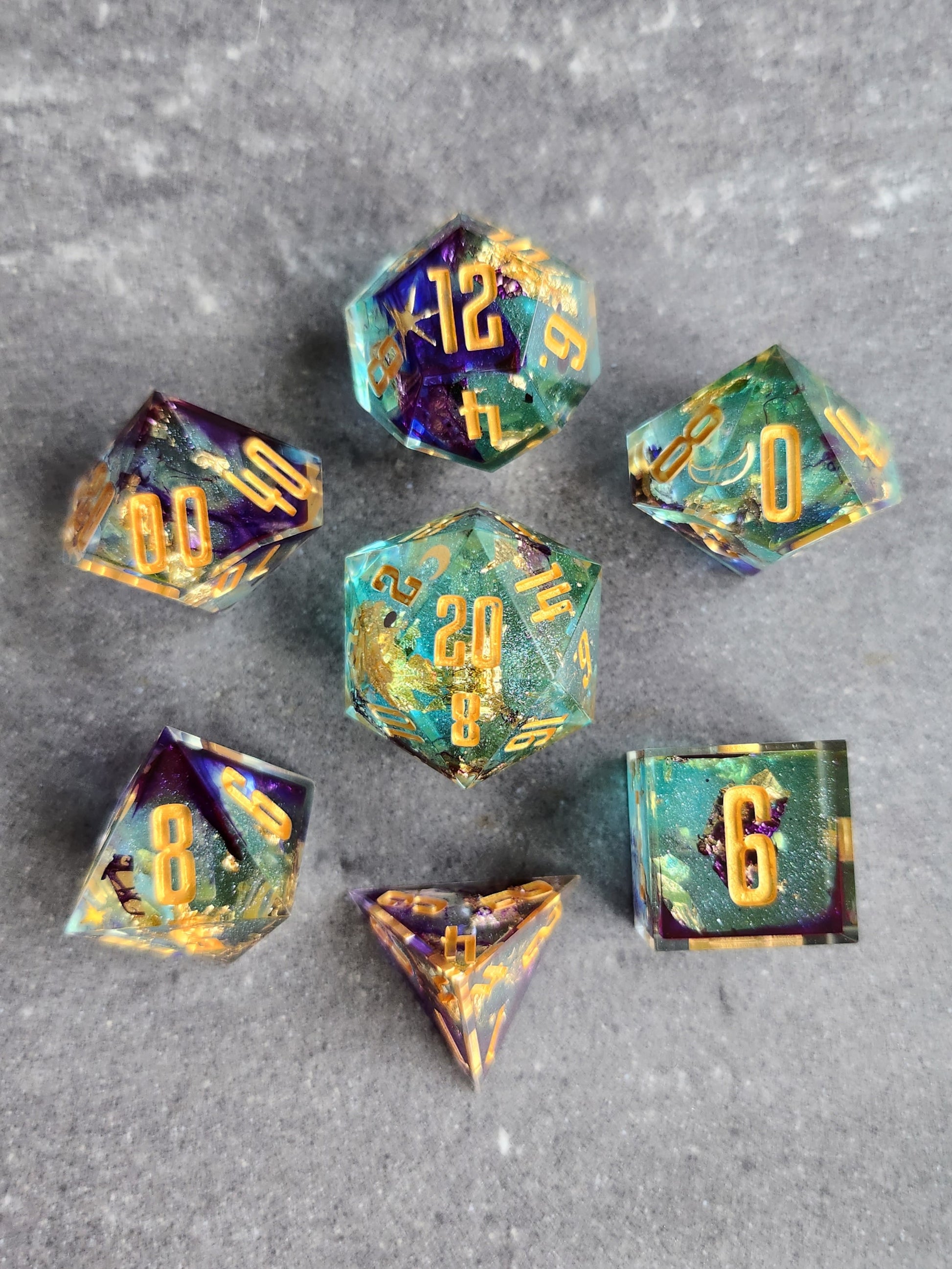 Set of dice with gold and teal colors on a gray background