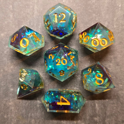 Set of colorful polyhedral dice with gold numbers on a gray background