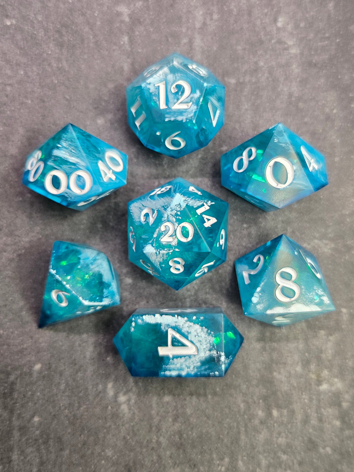 Set of blue polyhedral dice with white numbers on a gray background